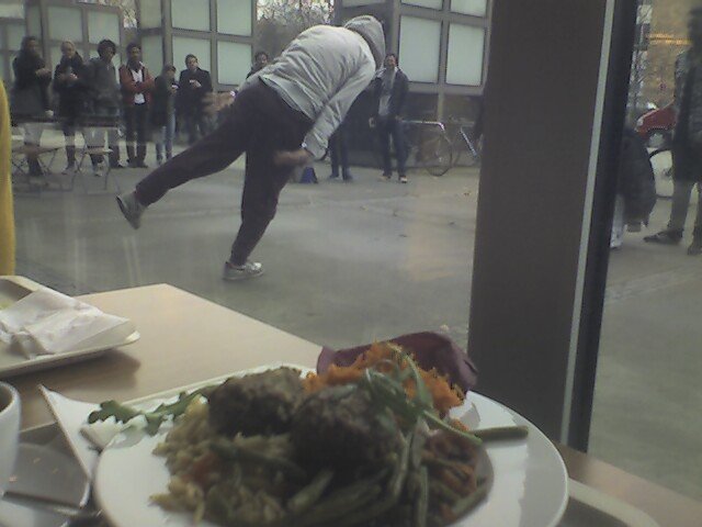 Im Vordergrund Köftebuletten auf Tomatenreisnudeln, Bohnengemüse und Möhren-Curcuma-Salat sowie Wolken im Kaffee. Im Hintergrund die heutige Break Dance-Kapelle; der Ghetto Blaster ist durch die Fensterlaibung verdeckt. Einer der Tanzenden konnte wirklich über Wasser gehen.